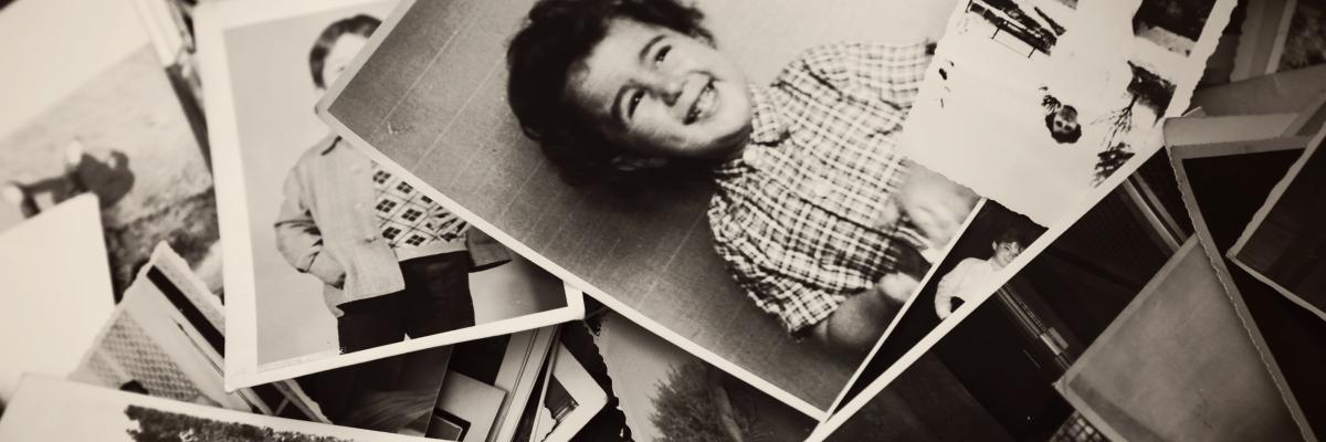 An assortment of old black and white family photos strewn in a pile