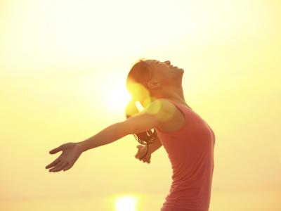 A woman standing in the sun, soaking up the light and warmth with pleasure