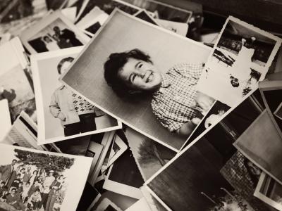 An assortment of old black and white family photos strewn in a pile